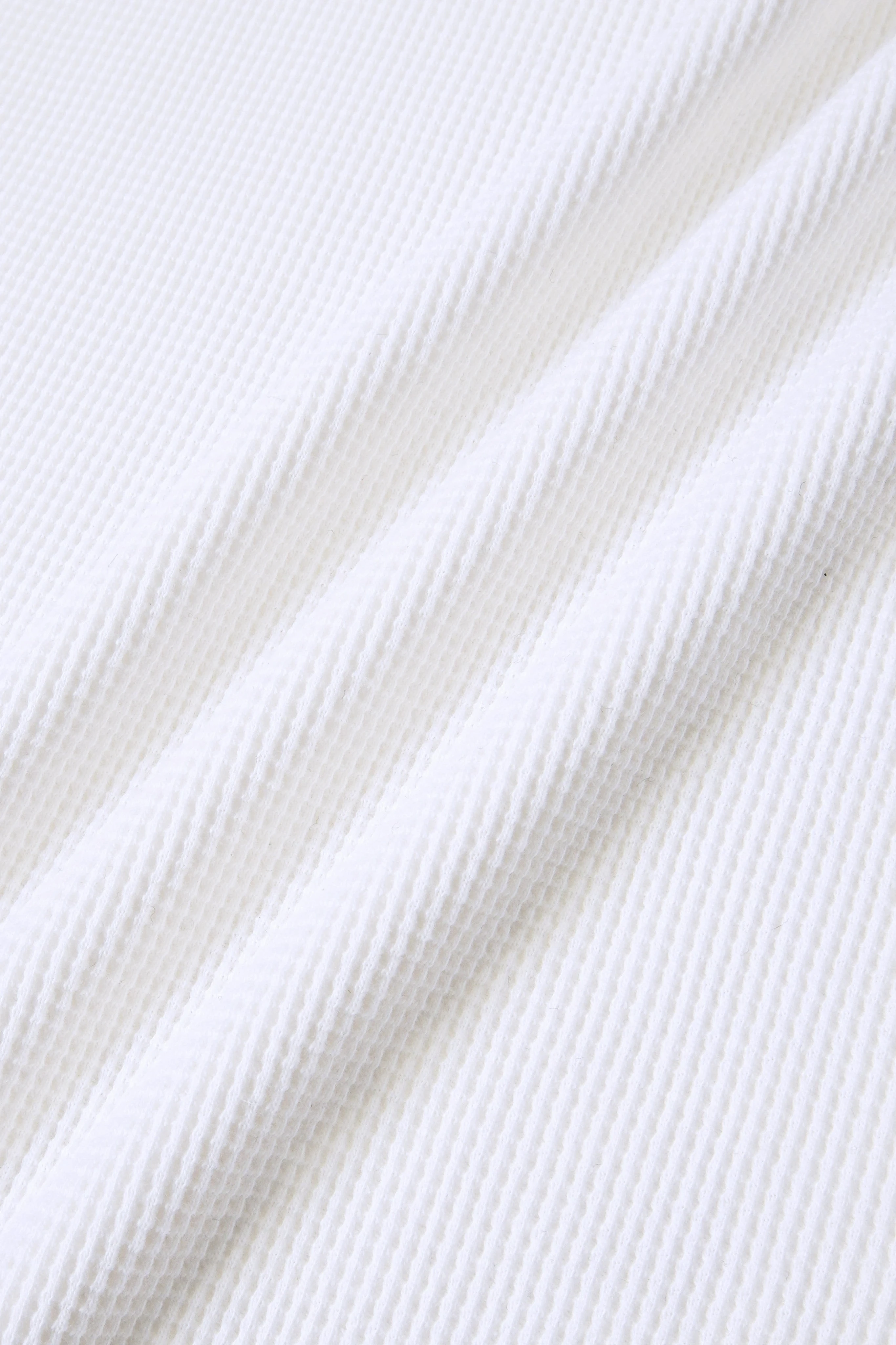 MEG.S white 100% cotton long sleeve waffle knit shirt with wide neck and split hem.