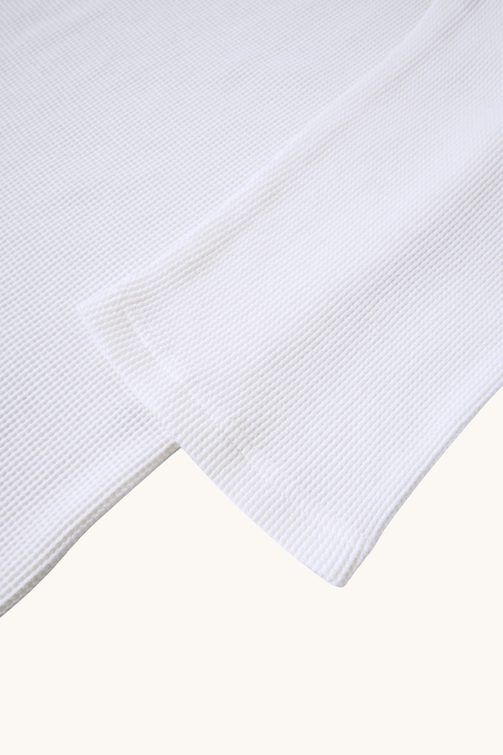MEG.S white 100% cotton long-sleeve waffle knit shirt with wide neck and split hem.