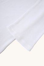 MEG.S white 100% cotton long-sleeve waffle knit shirt with wide neck and split hem.