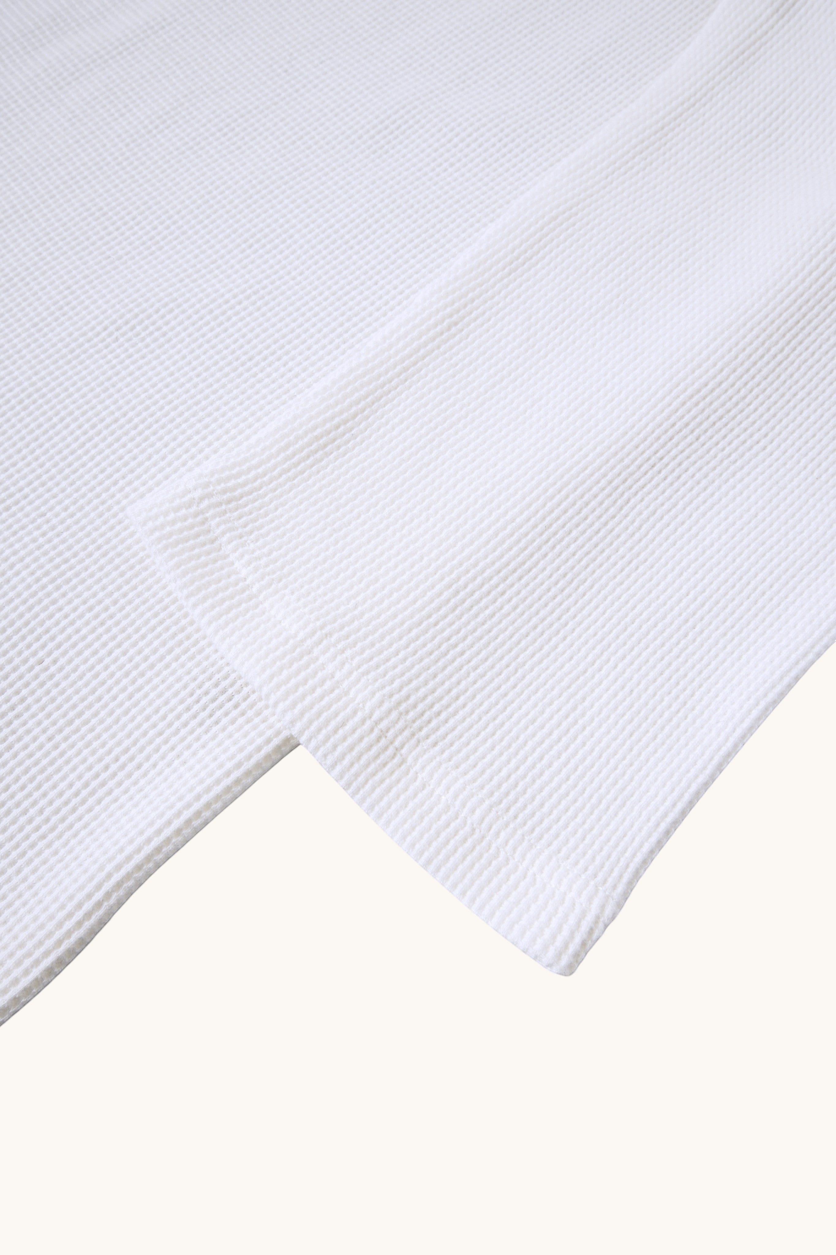 MEG.S white 100% cotton long-sleeve waffle knit shirt with wide neck and split hem.